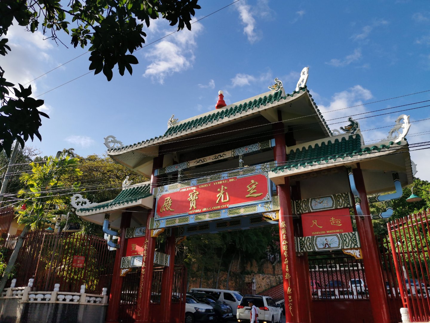 초록색 기와지붕과 붉은 지지 기둥, 한자 현판이 장식된 세부 도교 사원의 전통 입구 문.