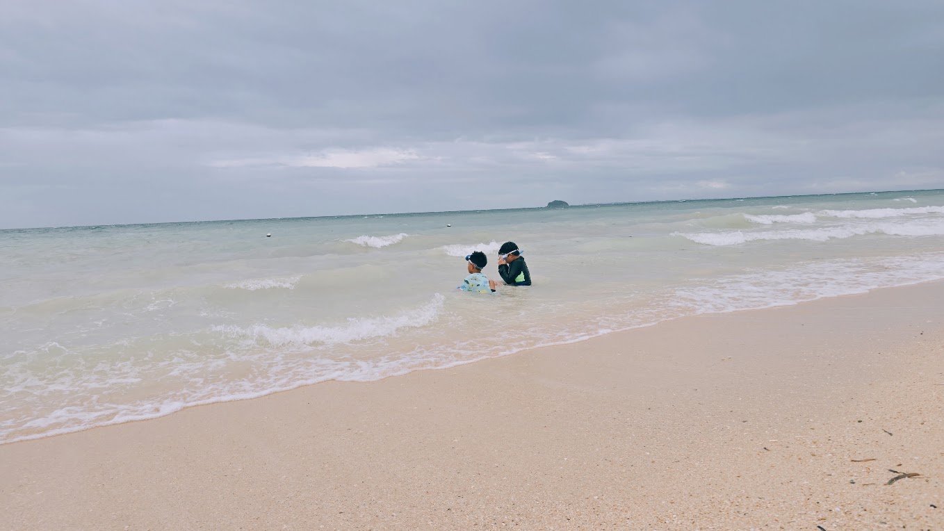 Two children wading in gentle sea waves at Suba Beach.