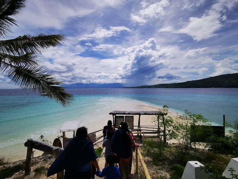 View of Sumilon Island's turquoise waters and coastline from a seaside walkway