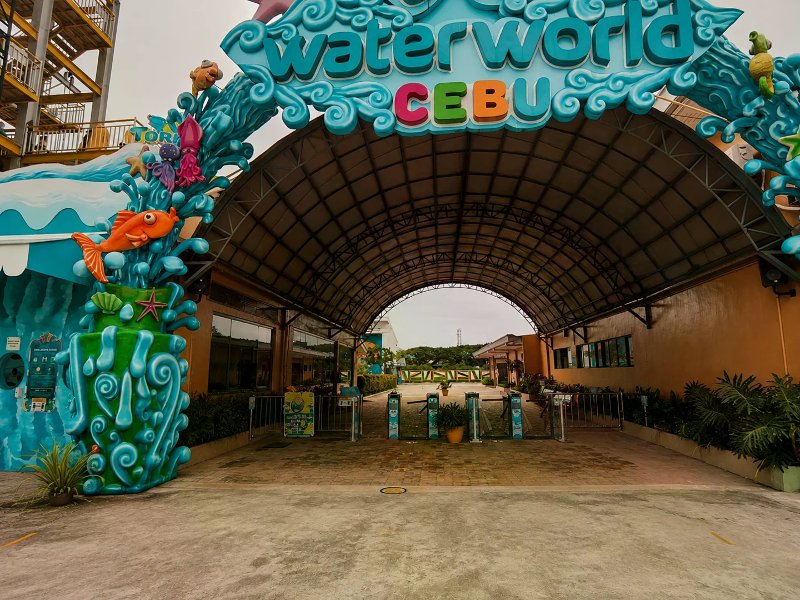 Colorful WaterWorld Cebu entrance arch with blue waves, sea creatures, and turnstile gates.